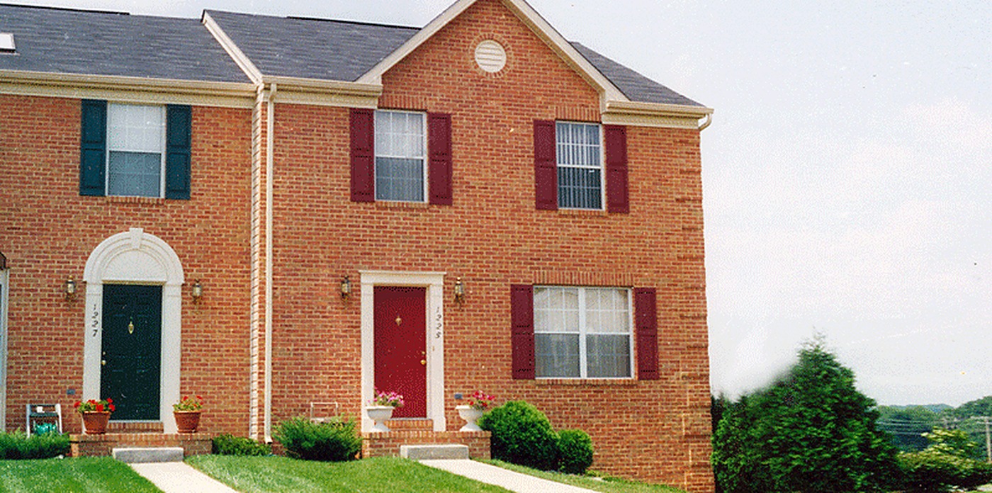 Brick townhome units with green and red front doors where we installed central vacuum systems