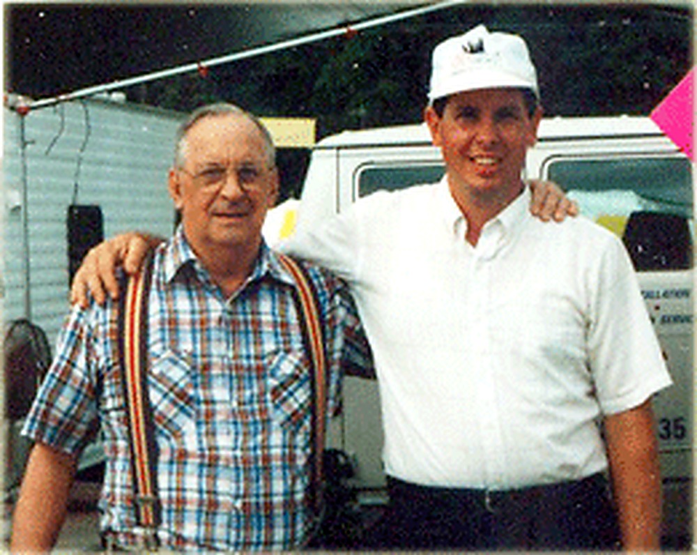 Oakley O'Bryan with his arm around his son Ernie O'Bryan in front of an A Plus Oaks service truck